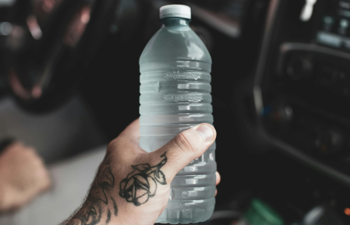 A close-up image of a transparent plastic water bottle, possibly containing microplastics invisible to the human eye,
